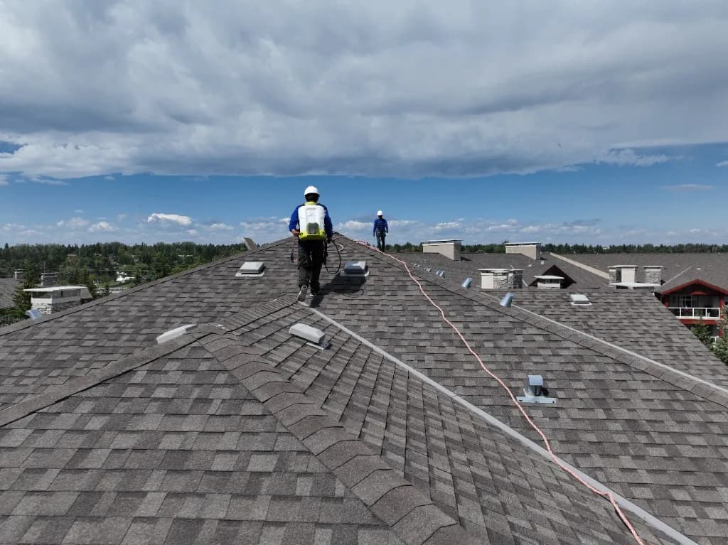 Nanoclad installers working on the condominium’s asphalt shingle roof.