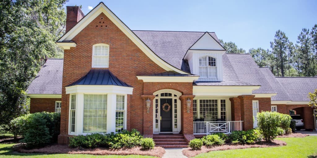 Brick home with a front entrance, bay window, and covered porch