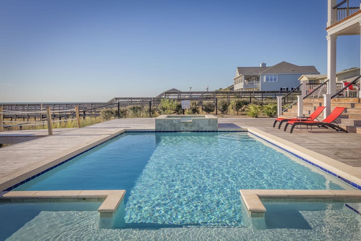 Resort swimming pool surrounded by a stone deck and lounge chairs